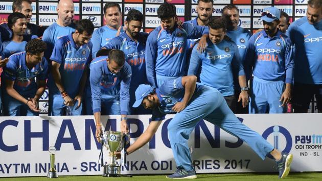 Indian cricket team captain Rohit Sharma (C) places the One Day series cup after winning the third One Day International (ODI) cricket match between India and Sri Lanka in Visakhapatnam on Sunday. (Noah Seelam / AFP)