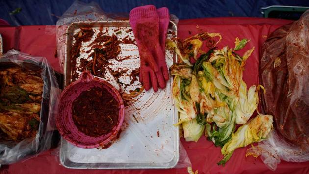 Cabbage, radish, red spicy paste and rubber gloves –all kimchi essentials. In the North, where UN statistics say around 40% of people are chronically undernourished, it flavours the rice that is the dietary mainstay. In the South, it accompanies cuisines from American to Vietnamese. But while authorities on both sides proclaim their commitment to reunification, more than 70 years of total separation has led the two Koreas and also their kimchi on divergent paths. (Ed Jones / AFP)