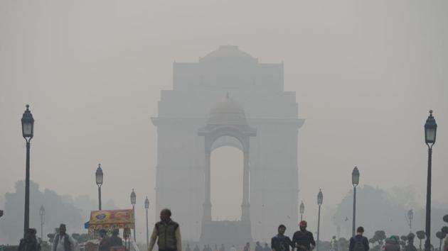 Indian residents walk amid heavy smog at India Gate in New Delhi.(AFP)