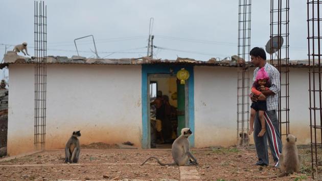 Mallikarjuna Reddy carries his nephew Samarth outside his home so that he can play with the monkeys in Allapur. Reddy said it was “strange” for the monkeys to behave like that, and villagers feared the boy would be attacked while his parents worked in a nearby field. (Manjunath Kiran / AFP)