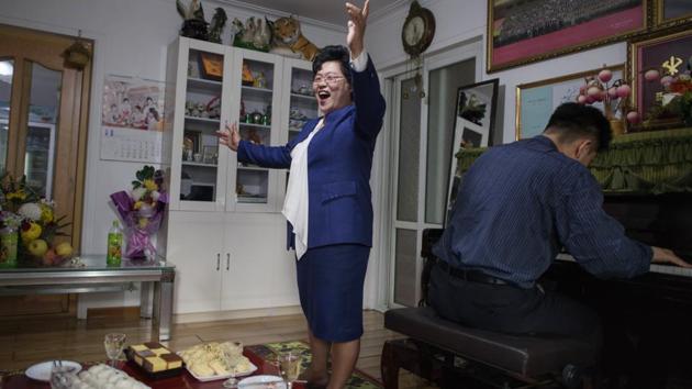 Song Song-Hui (C) sings in her apartment during a family gathering in Pyongyang, North Korea. They were listed separately on UNESCO’s roster of the world’s intangible cultural heritage, with the South’s inscribed first, but in her central Pyongyang flat, Song Song-Hui offers a patriotic defence of the North’s variety. “I have never tried kimchi from the south but I think the Pyongyang kimchi is much better than the kimchi from the south,” she said. (Ed Jones / AFP)