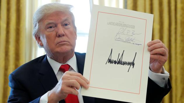 US President Donald Trump displays his signature after signing the $1.5 trillion tax overhaul plan in the Oval Office of the White House in Washington. (REUTERS) US President Donald Trump displays his signature after signing the $1.5 trillion tax overhaul plan in the Oval Office of the White House in Washington. (REUTERS)