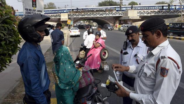 Traffic police officers in New Delhi fine a bike rider for not wearing a helmet. (Sonu Mehta/HT Photo) Traffic police officers in New Delhi fine a bike rider for not wearing a helmet. (Sonu Mehta/HT Photo)