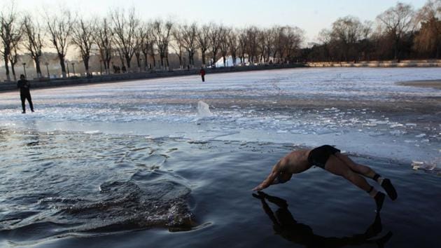 A ice swimmer dives into a partly frozen lake in Shenyang in China's northeastern Liaoning province on December 18, 2017. Winter swimming is believed to improve blood circulation and benefit health. (AFP) A ice swimmer dives into a partly frozen lake in Shenyang in China's northeastern Liaoning province on December 18, 2017. Winter swimming is believed to improve blood circulation and benefit health. (AFP)