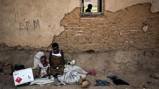 Displaced pygmies sit with their belongings outside a classroom, which serves as their shelter by night, on December 16, 2017 in Oicha. Displaced from deep in the forests, they are now struggling to adapt to more urban villages. Attacks allegedly carried out by the Ugandan Muslim Group, ADF in Eastern Democratic Republic of the Congo (DRC), have displaced thousands of Pygmies. (John Wessels / AFP) Displaced pygmies sit with their belongings outside a classroom, which serves as their shelter by night, on December 16, 2017 in Oicha. Displaced from deep in the forests, they are now struggling to adapt to more urban villages. Attacks allegedly carried out by the Ugandan Muslim Group, ADF in Eastern Democratic Republic of the Congo (DRC), have displaced thousands of Pygmies. (John Wessels / AFP)