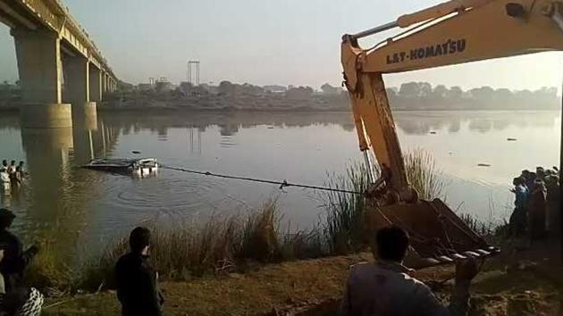 The ill-fated bus being pulled out from the river by a crane.(HT Photo)