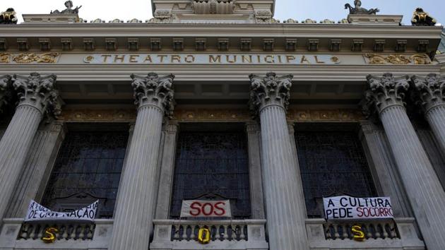 Protest banners by artists of the Municipal Theatre protesting against the non-payment of their salaries and the economic crisis are displayed on the facade of the theatre in Rio de Janeiro. Salaries have been delayed intermittently since 2015 as Rio’s finances began to falter from a deep recession and the cost of hosting the 2016 Olympic Games. But dancers and singers say the crisis now is unprecedented in the theatres history. (Ricardo Moraes / REUTERS) Protest banners by artists of the Municipal Theatre protesting against the non-payment of their salaries and the economic crisis are displayed on the facade of the theatre in Rio de Janeiro. Salaries have been delayed intermittently since 2015 as Rio’s finances began to falter from a deep recession and the cost of hosting the 2016 Olympic Games. But dancers and singers say the crisis now is unprecedented in the theatres history. (Ricardo Moraes / REUTERS)