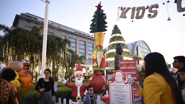 People take photographs in front of a Christmas tree at a mall in New Delhi on Saturday. (Burhaan Kinu / Hindustan Times) People take photographs in front of a Christmas tree at a mall in New Delhi on Saturday. (Burhaan Kinu / Hindustan Times)
