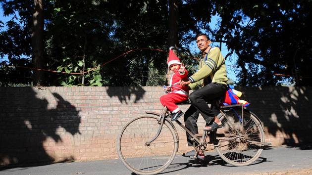Dressed as Santa Claus, a 4-year-old girl, Arshita, with her grandfather on the way to school, in Chandigarh on Saturday. (Anil Dayal/HT) Dressed as Santa Claus, a 4-year-old girl, Arshita, with her grandfather on the way to school, in Chandigarh on Saturday. (Anil Dayal/HT)