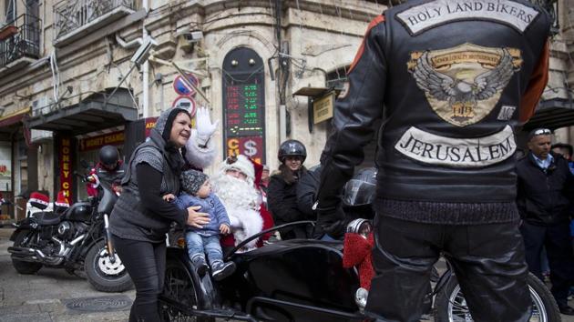 A man dressed as Santa Claus sits in a sidecar of a motorbike on Christmas Eve in Jerusalem Old City Sunday. (AP) A man dressed as Santa Claus sits in a sidecar of a motorbike on Christmas Eve in Jerusalem Old City Sunday. (AP)