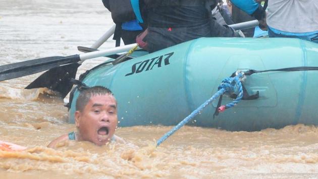 A man clings onto the rope of a rescue boat as residents are evacuated from their homes due to heavy flooding in Cagayan de Oro, Philippines. Footage showed vast tracts of land on the island submerged by brown water, often waist-deep, with streets turning into rivers. (Froilan Gallardo / REUTERS) A man clings onto the rope of a rescue boat as residents are evacuated from their homes due to heavy flooding in Cagayan de Oro, Philippines. Footage showed vast tracts of land on the island submerged by brown water, often waist-deep, with streets turning into rivers. (Froilan Gallardo / REUTERS)