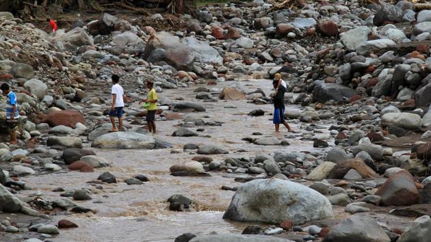 Residents walk on boulders swept inland by flashfloods in a village in Salvador on Sunday. Authorities in Vietnam are prepared to move up to a million people from low-lying areas along the southern coast on Monday as typhoon Tembin approaches after battering the Philippines. 74,000 people have been moved to safety from vulnerable areas and warnings put out for fishing boats to not venture out to sea. (Richel V. Umel / REUTERS) Residents walk on boulders swept inland by flashfloods in a village in Salvador on Sunday. Authorities in Vietnam are prepared to move up to a million people from low-lying areas along the southern coast on Monday as typhoon Tembin approaches after battering the Philippines. 74,000 people have been moved to safety from vulnerable areas and warnings put out for fishing boats to not venture out to sea. (Richel V. Umel / REUTERS)