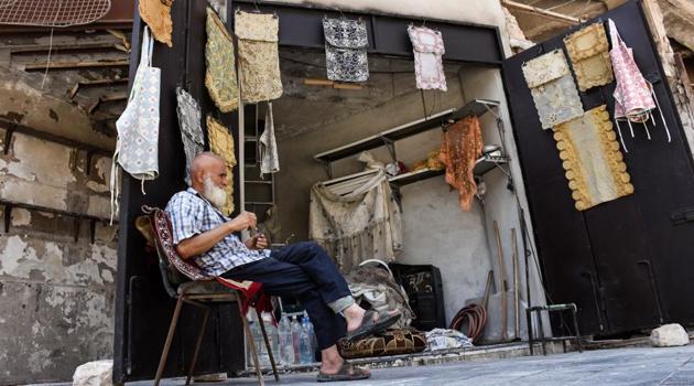 A picture taken on July 22, 2017, shows 62-year-old Mohammad Shawash sitting outside his textile shop amid the destruction in the old city of Aleppo. It used to be one of the most vibrant marketplaces in Syria's Aleppo, but today, the bombed-out streets of Khan al-Harir are home to a single, modest textile shop. (AFP Photo) A picture taken on July 22, 2017, shows 62-year-old Mohammad Shawash sitting outside his textile shop amid the destruction in the old city of Aleppo. It used to be one of the most vibrant marketplaces in Syria's Aleppo, but today, the bombed-out streets of Khan al-Harir are home to a single, modest textile shop. (AFP Photo)