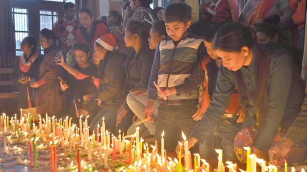 People lighting candles on the occasion of Christmas at a Church in Ludhiana on Monday. (Gurminder Singh/HT) People lighting candles on the occasion of Christmas at a Church in Ludhiana on Monday. (Gurminder Singh/HT)
