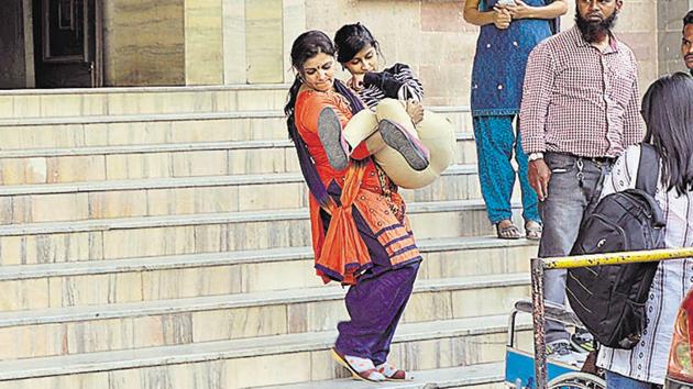 Diksha Dinde, a person with a disability, is carried down the strategies at the PMC main building because the structure does not have a ramp which Diksha could access on her wheelchair. (Rahul Raut/HT PHOTO) Diksha Dinde, a person with a disability, is carried down the strategies at the PMC main building because the structure does not have a ramp which Diksha could access on her wheelchair. (Rahul Raut/HT PHOTO)