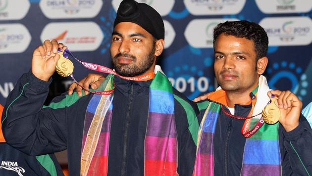 Vijay Kumar (R) and Gurpreet Singh pose with their gold medals won in the pairs 25m rapid fire pistol event at the 2010 Commonwealth Games in New Delhi.(Getty Images)