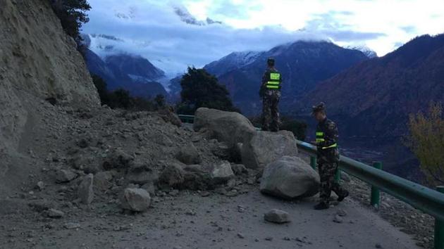 In this photo released by China’s Xinhua news agency, rescuers look at a road blocked by fallen rocks in Tibet region on November 18, 2017. Experts said three artificial lakes created after the quake may pose threat to Assam and Arunachal Pradesh.(AP) In this photo released by China’s Xinhua news agency, rescuers look at a road blocked by fallen rocks in Tibet region on November 18, 2017. Experts said three artificial lakes created after the quake may pose threat to Assam and Arunachal Pradesh.(AP)