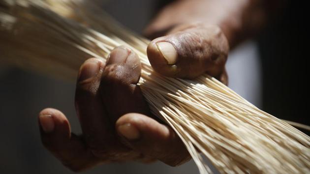 An artisan holds dried fibers before weaving them into a hat. “They don’t have anything (artificial), no machinery; no factory as such exists here in La Pintada,” said Reinaldo Quiros, who also sells hats out of his home. “Each artisan in his own home makes the hats maintaining the techniques taught by his ancestors.” (Arnulfo Franco / AP)