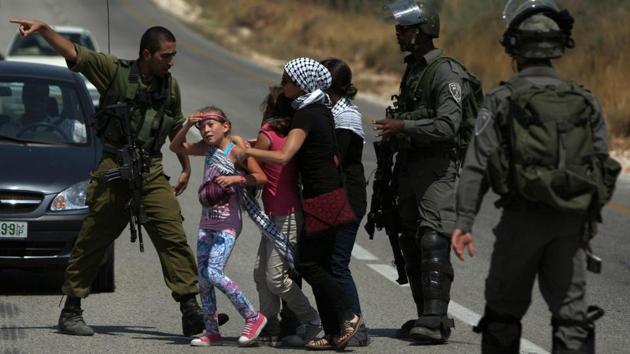 This June 29, 2012 photo shows Israeli forces preventing Ahed Tamimi (C-L) and relatives in Nabi Saleh from going into their property which had been confiscated to expand the Halamish settlement. “We should exact a price at some other opportunity, in the dark, without witnesses and cameras,” columnist Ben Caspit wrote to severe criticism. “The Tamimi family has to learn, the hard way, that such systematic provocations” come at great cost. (Abbas Momani / AFP File) This June 29, 2012 photo shows Israeli forces preventing Ahed Tamimi (C-L) and relatives in Nabi Saleh from going into their property which had been confiscated to expand the Halamish settlement. “We should exact a price at some other opportunity, in the dark, without witnesses and cameras,” columnist Ben Caspit wrote to severe criticism. “The Tamimi family has to learn, the hard way, that such systematic provocations” come at great cost. (Abbas Momani / AFP File)