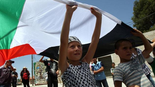 Ahed Tamimi hold up the Palestinian flag in a protest against the expropriation of Palestinian land, in Nabi Saleh on June 10, 2011. Ahed’s arrest has also turned attention to Nabi Saleh’s long-running disputes with the nearby Israeli settlement of Halamish, that residents say has stolen their land and water. (Abbas Momani / AFP File) Ahed Tamimi hold up the Palestinian flag in a protest against the expropriation of Palestinian land, in Nabi Saleh on June 10, 2011. Ahed’s arrest has also turned attention to Nabi Saleh’s long-running disputes with the nearby Israeli settlement of Halamish, that residents say has stolen their land and water. (Abbas Momani / AFP File)