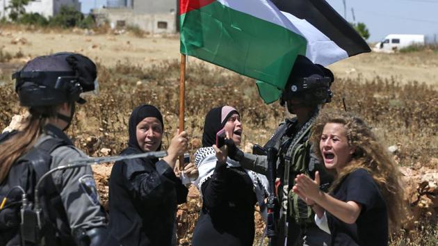 Ahed Tamimi (R) reacting in front of Israeli forces during a demonstration on May 26, 2017. The latest video, filmed in her backyard, occurred hours after a cousin was shot in the face with a rubber bullet, and was streamed live on Facebook on December 15. Her publicised arrest by the army in a night raid silenced some calls for punishment, but also launched a new social-media campaign: #FreeAhed. (Abbas Momani / AFP File) Ahed Tamimi (R) reacting in front of Israeli forces during a demonstration on May 26, 2017. The latest video, filmed in her backyard, occurred hours after a cousin was shot in the face with a rubber bullet, and was streamed live on Facebook on December 15. Her publicised arrest by the army in a night raid silenced some calls for punishment, but also launched a new social-media campaign: #FreeAhed. (Abbas Momani / AFP File)
