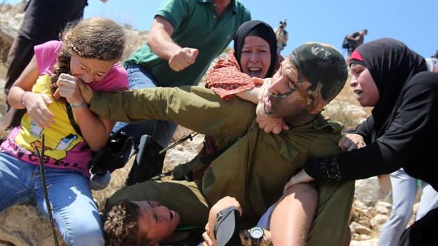 An August 28, 2015 image shows Ahed Tamimi (L) biting the hand of an Israeli soldier, trying to free her brother during clashes in Nabi Saleh. The encounter which was also caught on video is among Ahed Tamimi’s several with Israeli forces. “Restraint is a failed and dangerous policy,” said Oren Hazan, an Israeli member of parliament from the Likud Party. “Next time it must end differently.” (Abbas Momani / AFP File) An August 28, 2015 image shows Ahed Tamimi (L) biting the hand of an Israeli soldier, trying to free her brother during clashes in Nabi Saleh. The encounter which was also caught on video is among Ahed Tamimi’s several with Israeli forces. “Restraint is a failed and dangerous policy,” said Oren Hazan, an Israeli member of parliament from the Likud Party. “Next time it must end differently.” (Abbas Momani / AFP File)