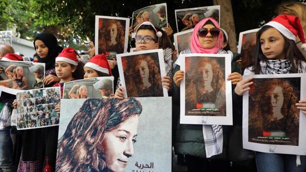 Demonstrators call for the release of Ahed Tamimi outside the International Committee of the Red Cross in Beirut on December 26, 2017. Wearing a keffiyeh over her denim jacket, Tamimi was filmed screaming in Arabic, repeatedly punching, slapping and kicking armed Israeli army officers who stood passively. As the soldiers walked away, debates spurred in Israel over whether the soldiers’ restraint was virtuous or a national embarrassment. (Anwar Amro / AFP) Demonstrators call for the release of Ahed Tamimi outside the International Committee of the Red Cross in Beirut on December 26, 2017. Wearing a keffiyeh over her denim jacket, Tamimi was filmed screaming in Arabic, repeatedly punching, slapping and kicking armed Israeli army officers who stood passively. As the soldiers walked away, debates spurred in Israel over whether the soldiers’ restraint was virtuous or a national embarrassment. (Anwar Amro / AFP)