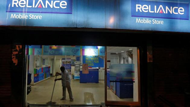 A worker cleans a mobile store of Reliance Communications Ltd in Kolkata, in September 2016. RCom and other telecom companies have been hurt by intense price competition, and piled on debt in their quest for expansion of market share.(Reuters Photo)