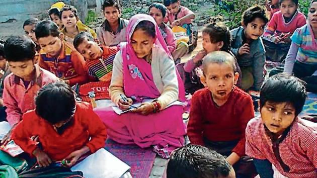 Ramwati (centre) studies with students at the Qazimabad primary school in Atrauli, Aligarh. (Mahipal Singh /Hindustan Times) Ramwati (centre) studies with students at the Qazimabad primary school in Atrauli, Aligarh. (Mahipal Singh /Hindustan Times)