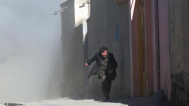 An Afghan man runs to safety as dust blows in the aftermath of the third blast at a Shiite cultural centre in Kabul. Afghan forces have pushed the Taliban back in many areas and prevented major urban centres from falling into the hands of insurgents. But high-profile attacks in the big cities have continued as militants have looked for other ways to make an impact. (Shah Marai / AFP)