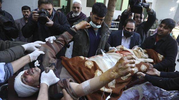 People carry an injured man into the hospital after the suicide attacks in Kabul. The attack, the latest in a series to hit Afghan media groups in recent years, follows an attack on a private television station in Kabul last month. (Rahmat Gul / AP)