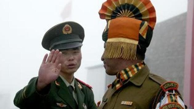 This file photo shows a Chinese soldier gesturing next to an Indian soldier at the Nathu La border crossing between India and China in Sikkim. (AFP File Photo) This file photo shows a Chinese soldier gesturing next to an Indian soldier at the Nathu La border crossing between India and China in Sikkim. (AFP File Photo)