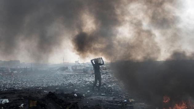 A young man carries electronic waste at Agbogbloshie dumpsite in Accra. The young workers wish to live in a world where they do not have to burn waste for survival. A 26-year-old worker at the site says, “Some people think we are bad because they think we are mad. If we get money no one will look at us like that. Some day will come when no one will be working here.” (Cristina Aldehuela / AFP) 