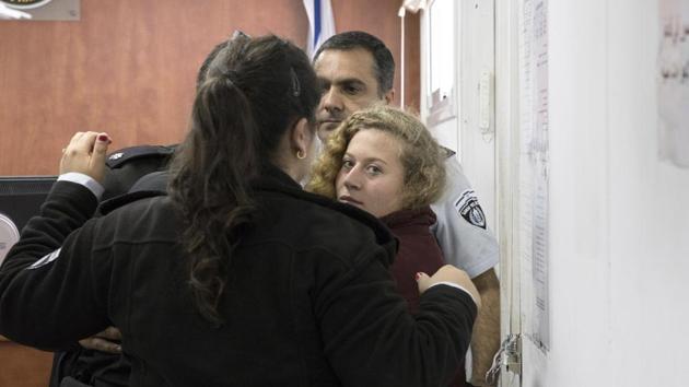 Palestinian Ahed Tamimi Is escorted at a military court near Jerusalem, Wednesday, Dec. 20, 2017. The 16-year-old girl who is seen in a video kicking and pushing two Israeli soldiers near her West Bank home is being celebrated by Palestinians. (AP) Palestinian Ahed Tamimi Is escorted at a military court near Jerusalem, Wednesday, Dec. 20, 2017. The 16-year-old girl who is seen in a video kicking and pushing two Israeli soldiers near her West Bank home is being celebrated by Palestinians. (AP)