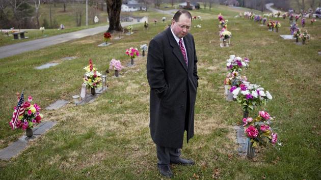 Steven Whitt checks the date on a tombstone as part of his funeral home business in Sandy Hook. The Whitts cobble together a living with a couple jobs. It represents the cracks in America that drove Whitt, a lifelong Democrat, from supporting Obama to buying a “Make America Great Again” cap he still keeps. He blames the “brick wall” in Washington blocking everything Trump proposes while “small people” like them are left again to languish. (David Goldman / AP) Steven Whitt checks the date on a tombstone as part of his funeral home business in Sandy Hook. The Whitts cobble together a living with a couple jobs. It represents the cracks in America that drove Whitt, a lifelong Democrat, from supporting Obama to buying a “Make America Great Again” cap he still keeps. He blames the “brick wall” in Washington blocking everything Trump proposes while “small people” like them are left again to languish. (David Goldman / AP)