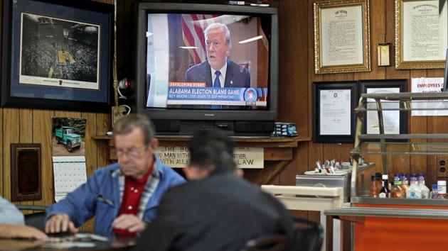 A newscast on President Trump plays as customers play cards in the Frosty Freeze restaurant in Sandy Hook, Kentucky on December 14, 2017. Everyone in town comes to this diner for nostalgia and homestyle cooking. And recently, reporters came from all over the world to puzzle over politics — because Elliott County, a blue-collar union stronghold, voted for the Democrat in each and every presidential election for its 147-year existence. Until Donald Trump came along. (David Goldman / AP) A newscast on President Trump plays as customers play cards in the Frosty Freeze restaurant in Sandy Hook, Kentucky on December 14, 2017. Everyone in town comes to this diner for nostalgia and homestyle cooking. And recently, reporters came from all over the world to puzzle over politics — because Elliott County, a blue-collar union stronghold, voted for the Democrat in each and every presidential election for its 147-year existence. Until Donald Trump came along. (David Goldman / AP)