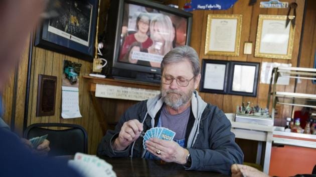 Wes Lewis plays cards with fellow regulars at the Frosty Freeze. “He’s already done enough to get my vote again,” Lewis says. He thinks the mines and the factories will soon roar back to life, and if they don’t, he believes they would have if Democrats, Republicans and the media had gotten out of the way. What Lewis has after Trump is a belief that his president is pulling for people like him. (David Goldman / AP) Wes Lewis plays cards with fellow regulars at the Frosty Freeze. “He’s already done enough to get my vote again,” Lewis says. He thinks the mines and the factories will soon roar back to life, and if they don’t, he believes they would have if Democrats, Republicans and the media had gotten out of the way. What Lewis has after Trump is a belief that his president is pulling for people like him. (David Goldman / AP)