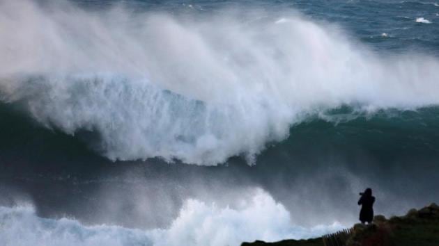 A photographer takes pictures of waves breaking on the Brittany coast at Audierne in western France on December 27, 2017. (Mal Langsdon / REUTERS) A photographer takes pictures of waves breaking on the Brittany coast at Audierne in western France on December 27, 2017. (Mal Langsdon / REUTERS)