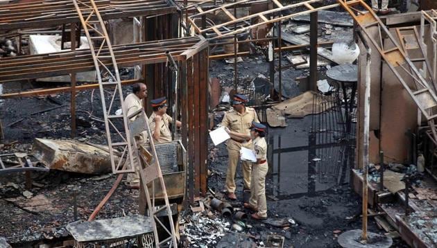 A police team inspects the debris after a fire broke out in Mumbai on Friday. At least 14 people were killed in the fire in Kamala Mills Compound in Lower Parel.(PTI)