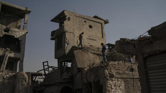 Workers stand atop damaged buildings in the Old City of Mosul. All five bridges crossing the Tigris have been disabled by airstrikes, forcing all traffic onto a single-lane. The two effective battles for Mosul have been likened by military experts to the 1968 battle for the Vietnamese city of Hue. Some like Stephen Wood, a senior analyst at the satellite imagery firm DigitalGlobe look even further back to Dresden, or pictures of World War II. (Felipe Dana / AP) Workers stand atop damaged buildings in the Old City of Mosul. All five bridges crossing the Tigris have been disabled by airstrikes, forcing all traffic onto a single-lane. The two effective battles for Mosul have been likened by military experts to the 1968 battle for the Vietnamese city of Hue. Some like Stephen Wood, a senior analyst at the satellite imagery firm DigitalGlobe look even further back to Dresden, or pictures of World War II. (Felipe Dana / AP)