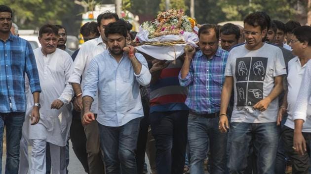 Piyush Dhirani (light blue shirt) carries his wife Kavita Dharani’s body for cremation. Kavita died in a fire in Mumbai that killed 13 others on Thursday night.(Pratik Chorge/HT Photo)