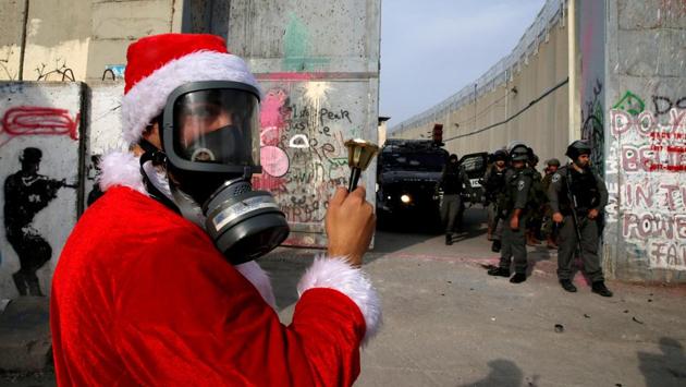 A Palestinian dressed as Santa Claus faces Israeli troops during a protest in the West Bank city of Bethlehem on December 23, 2017. (Ammar Awad / REUTERS) A Palestinian dressed as Santa Claus faces Israeli troops during a protest in the West Bank city of Bethlehem on December 23, 2017. (Ammar Awad / REUTERS)