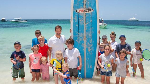 Roger Federer poses with local children after giving them a tennis lesson on a beach at Rottnest Island off the coast of Western Australia. (AFP)