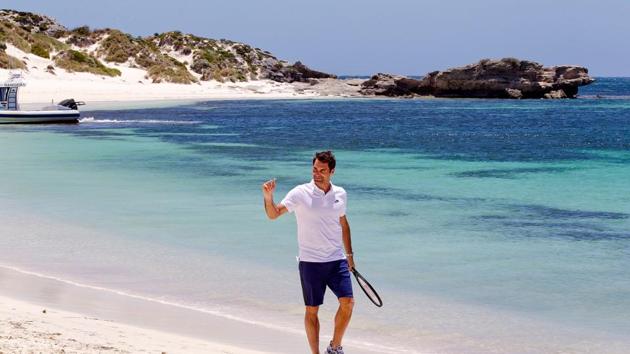 Roger Federer walks along a beach with a tennis racquet at Rottnest Island off the coast of Western Australia. (AFP)