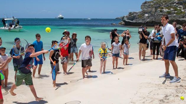 Roger Federer gives local children a tennis lesson on a beach at Rottnest Island off the coast of Western Australia. (AFP)