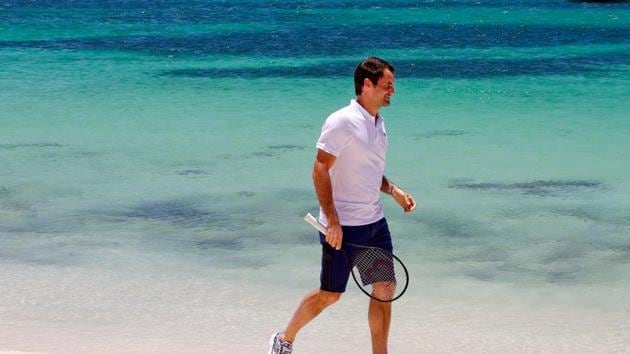 Roger Federer walks along a beach at Rottnest Island off the coast of Western Australia and gives children a smile as he gives them lessons. (AFP)