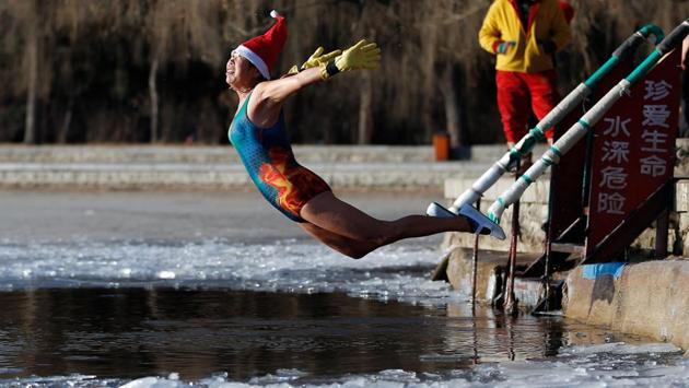 A woman wearing a Santa hat dives into a partly frozen lake in Shenyang in China's northeastern Liaoning province on December 25, 2017. (AFP) A woman wearing a Santa hat dives into a partly frozen lake in Shenyang in China's northeastern Liaoning province on December 25, 2017. (AFP)