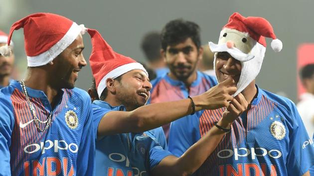 Mahendra Singh Dhoni (R) wears a Santa Claus cap as teammates Kuldeep Yadav (C) and Hardik Pandya (L) look on during celebrations after India won the third T20 international cricket match against Sri Lanka at the Wankhede Stadium in Mumbai on December 24, 2017. (Punit Paranjpe / AFP)