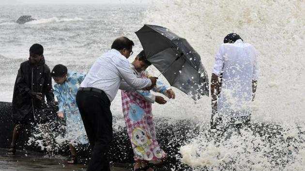 People enjoy being splashed by waves during high tide at Worli Seaface in Mumbai.  (Kunal Patil / HT Photo) 