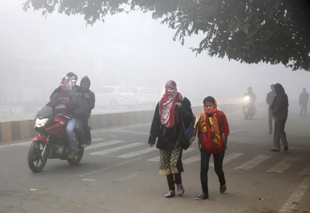 People cover themselves up with heavy woollens as they ride and walk on a cold and foggy morning in Allahabad. (AP) People cover themselves up with heavy woollens as they ride and walk on a cold and foggy morning in Allahabad. (AP)